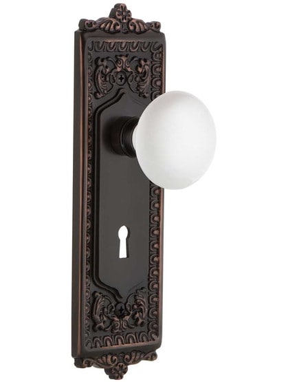 Egg and Dart Door Set with White Porcelain Knobs and Keyhole in Timeless Bronze.